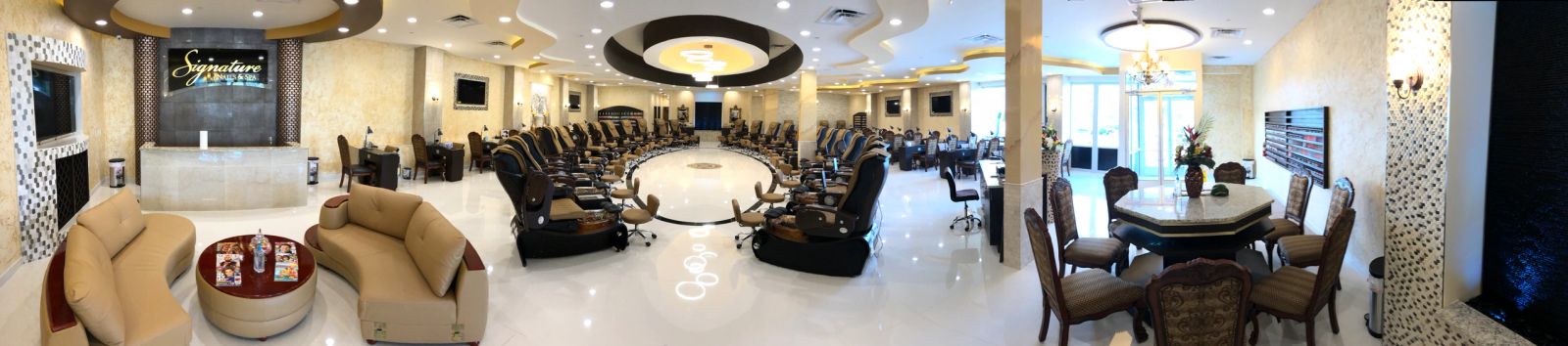 Wide panoramic view of a finished nail salon and spa, lit end to end.