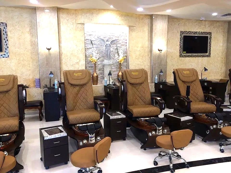 A finished salon with pedicure chairs, wall sconces and recessed downlights throughout.